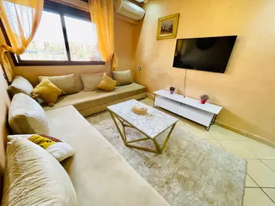 a living room with a couch and a tv at Centre ville Majorelle avec Parking gratuit in Marrakech