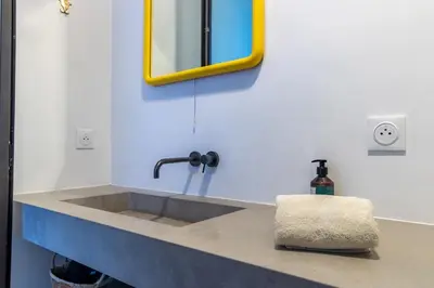 a sink in a bathroom with a yellow mirror at Riad Doum Collection 2 in Marrakech