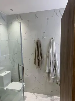 a bathroom with a shower and a toilet and towels at Appartement Cosy in Marrakech