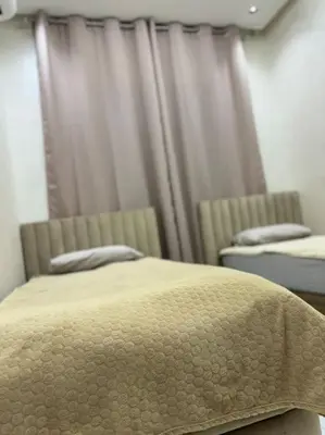 a bedroom with two beds and curtains in a room at Appartement Cosy in Marrakech