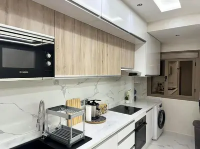 a white kitchen with a sink and a microwave at Appartement Cosy in Marrakech