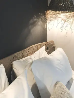 a bed with white pillows and a lamp at Riad Dar-K in Marrakech