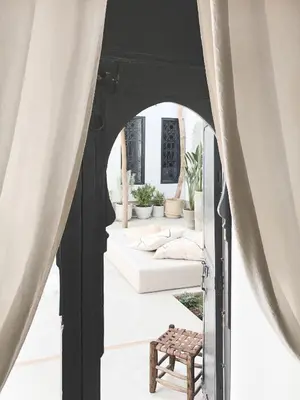 an archway with curtains and a bench in a room at Riad Dar-K in Marrakech