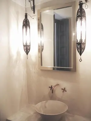 a bathroom with a sink and two chandeliers and a mirror at Riad Dar-K in Marrakech