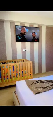 a bedroom with two televisions on a striped wall at Appartement calme et élégant au coeur de Marrakech in Marrakech