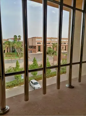 a white car parked outside of a window at Appartement calme et élégant au coeur de Marrakech in Marrakech