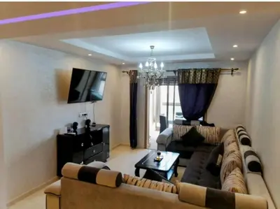 a living room with a couch and a tv at Appartement calme et élégant au coeur de Marrakech in Marrakech