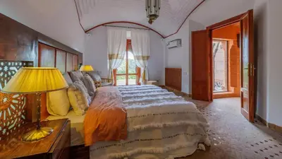 a bedroom with a large bed and a lamp at Villa Fairway One Amelkis in Sfiani