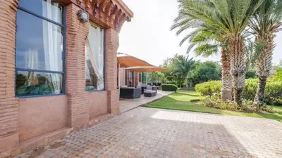 a house with a palm tree next to a building at Villa Fairway One Amelkis in Sfiani