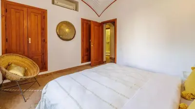 a bedroom with a white bed and a chair at Villa Fairway One Amelkis in Sfiani
