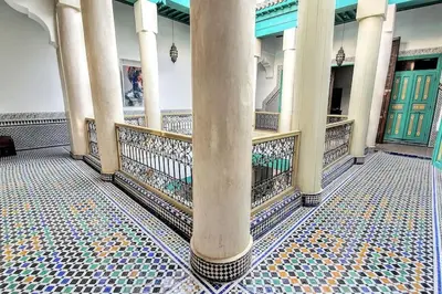 a building with columns and a tiled floor with doors at Riad LakLak Tradition 350m2 in der Medina mit Terrasse in Marrakech