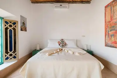 a bedroom with a bed with a white comforter at Riad LakLak Tradition 350m2 in der Medina mit Terrasse in Marrakech