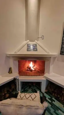 a living room with a fire in a fireplace at Riad LakLak Tradition 350m2 in der Medina mit Terrasse in Marrakech