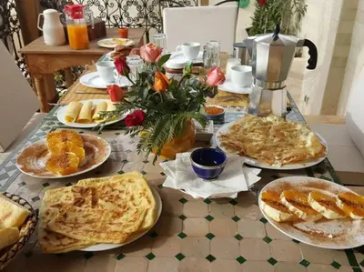 a table with plates of food on top at Riad LakLak Tradition 350m2 in der Medina mit Terrasse in Marrakech
