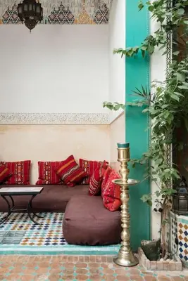 a room with a couch with red pillows on it at Riad LakLak Tradition 350m2 in der Medina mit Terrasse in Marrakech