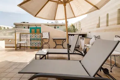 a patio with a table and an umbrella at Riad LakLak Tradition 350m2 in der Medina mit Terrasse in Marrakech