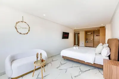 a white bedroom with a bed and a couch at New Duplex Haut Standing à Victor Hugo, Gueliz in Marrakech