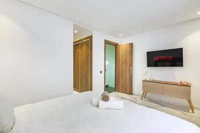 a white bedroom with a bed and a desk at New Duplex Haut Standing à Victor Hugo, Gueliz in Marrakech