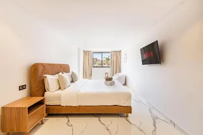 a white bedroom with a bed and a window at New Duplex Haut Standing à Victor Hugo, Gueliz in Marrakech