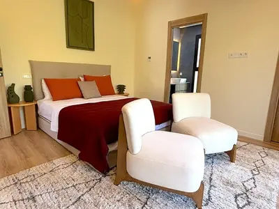 a bedroom with a bed and two white chairs at Palais Siham in Marrakech