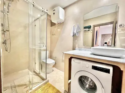 a bathroom with a washing machine and a sink at Appartement elegant et securise au centre de Marrakech in Marrakech