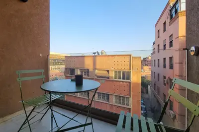 a table and chairs on a balcony with a view at Appartement elegant et securise au centre de Marrakech in Marrakech