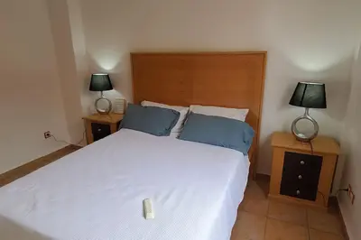a bedroom with a large white bed with two lamps at Appartement bien équipé à louer in Marrakech