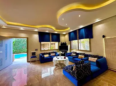 a large living room with blue couches and a table at Villa des Ocres - Élégance et Luxe à 15 min du centre ! in Marrakech