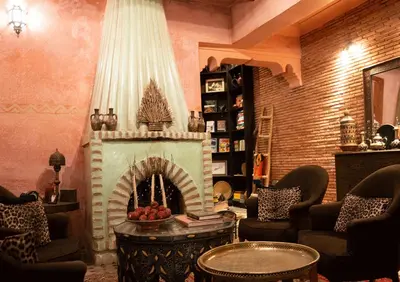 a living room with a fireplace in front of it at Riad Amirat Al Jamal in Marrakech