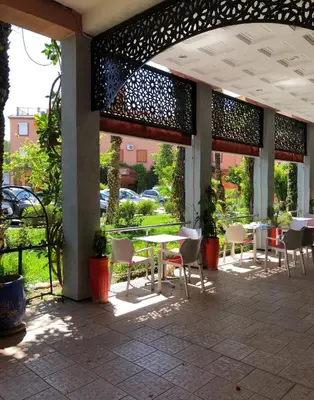 a patio with tables and chairs in a building at M-S Riad in Marrakech