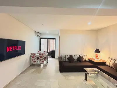 a living room with a couch and a table at Le Spacieux de Gueliz avec Piscine et Terasse in Marrakech