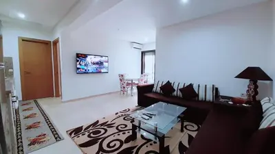a living room with a couch and a table at Le Spacieux de Gueliz avec Piscine et Terasse in Marrakech