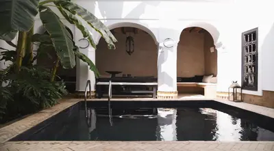 a pool in the middle of a room with a house at Riad Muarid in Marrakech