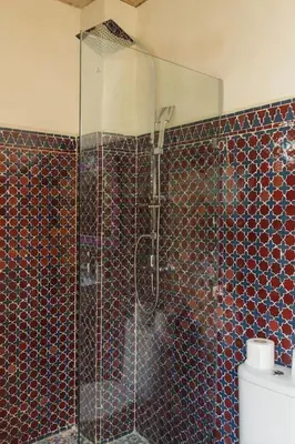 a bathroom with a glass shower with a toilet at Riad Pistache 135m2 in der Medina mit Terrasse in Marrakech