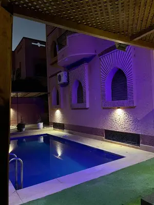 a swimming pool with purple lighting in a building at Villa riad al salam in Marrakech