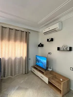 a living room with a flat screen tv sitting on a cabinet at Cosy Appartement Famille in Marrakech