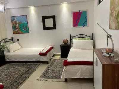 a room with two beds and a desk with a desk at Majorelle Chillax in Marrakech