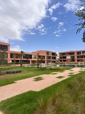 a walkway in front of a building with a park at Luxueux appartement Golf Noria in El Makina