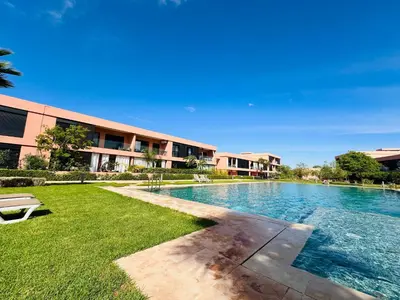 a swimming pool in front of a building at Luxueux appartement Golf Noria in El Makina