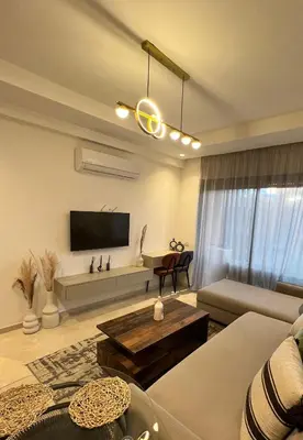 a living room with a couch and a tv at Luxueux appartement Golf Noria in El Makina