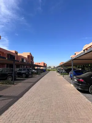 a parking lot with cars parked next to buildings at Luxueux appartement Golf Noria in El Makina