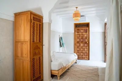 a bedroom with a bed and a wooden cabinet at Riad Eden Dorient in Marrakech