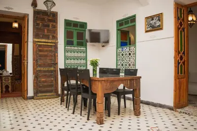 a dining room with a wooden table and chairs at Riad Moulaty 205m2 in der Medina mit Terrasse in Marrakech