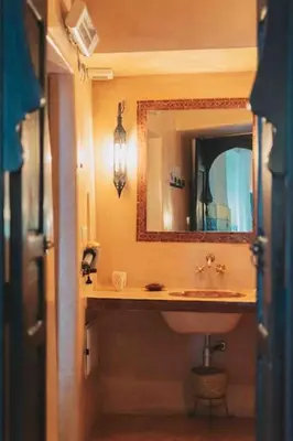 a bathroom with a sink and a mirror at Riad Bouhalla 240m2 in der Medina mit Terrasse in Marrakech