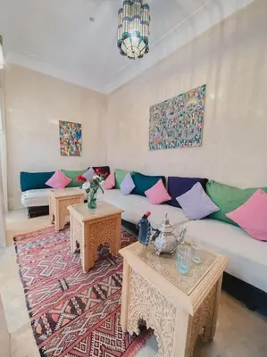 a living room with a couch and two tables at Riad Bouhalla 240m2 in der Medina mit Terrasse in Marrakech