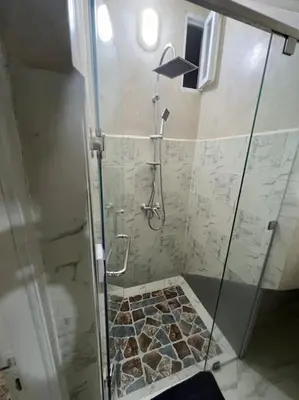 a shower with a glass door in a bathroom at Cozy Apartment Near Airport Terminal Modern Apartment Close to Airport in Marrakech