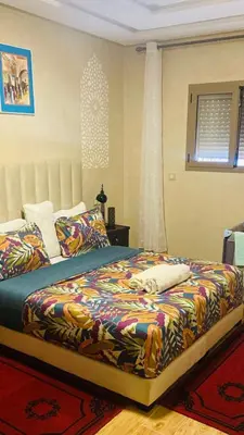a bedroom with a large bed with a colorful blanket at Cozy Apartment Near Airport Terminal Modern Apartment Close to Airport in Marrakech