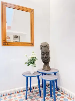 a statue sitting on two blue tables next to a mirror at Riad Dar Cidi 100m2 in der Medina mit Terrasse in Marrakech