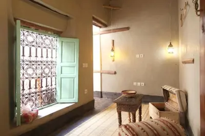 a room with a window and a couch and a table at Riad Petit Palais 100m2 in der Medina mit Terrasse in Marrakech