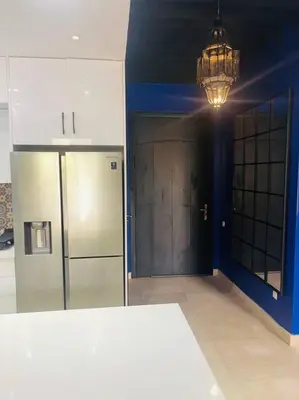 a kitchen with a refrigerator and a chandelier at Les Jardin d'Atlas golf and Waky with private Pool in Marrakech
